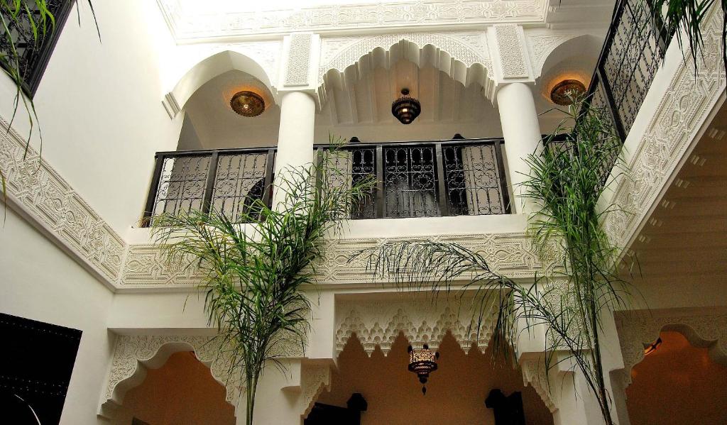 a building with potted plants and a balcony at Hotel Riad Todos in Marrakech