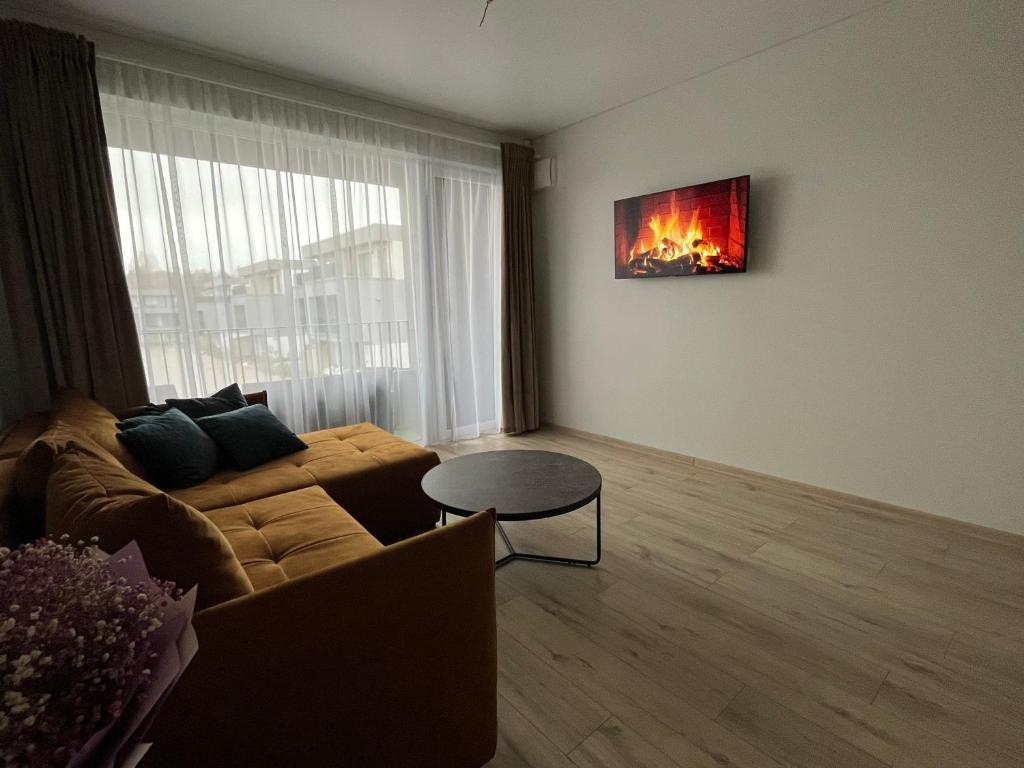 uma sala de estar com um sofá e uma mesa em Mano Jūra 2, Kunigiškiai - Viltės Apartamentai em Palanga