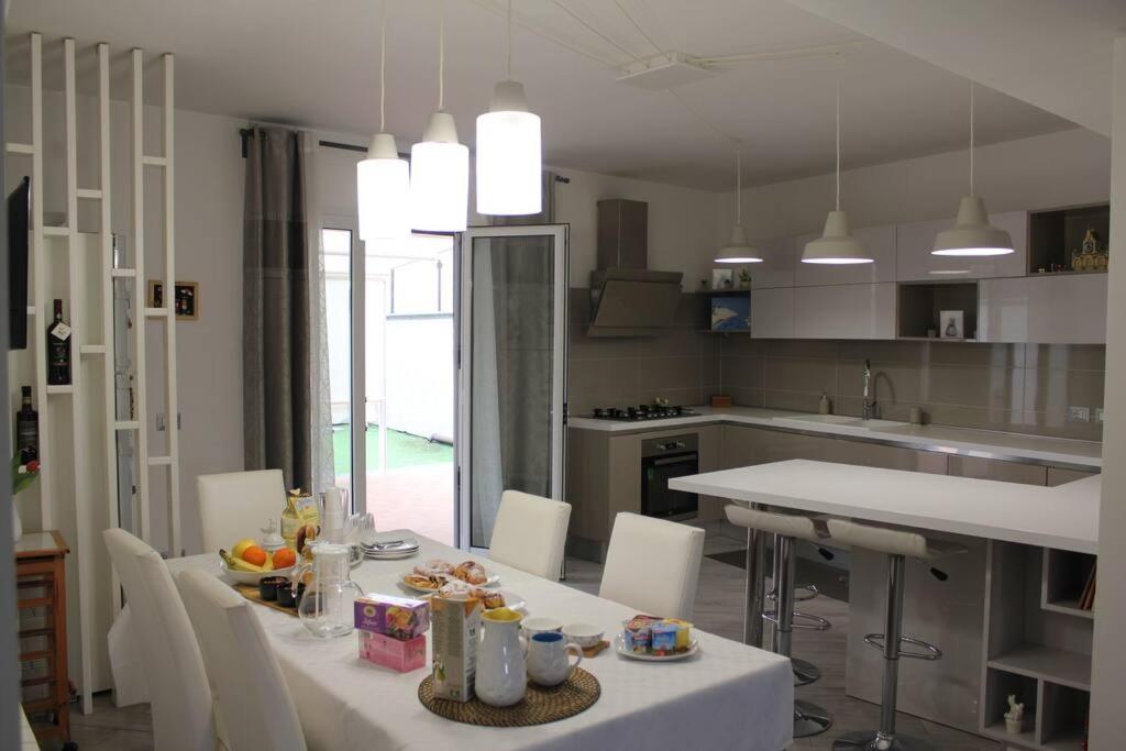 a kitchen with a white table and white chairs at Villa Adriana B&B in Misterbianco