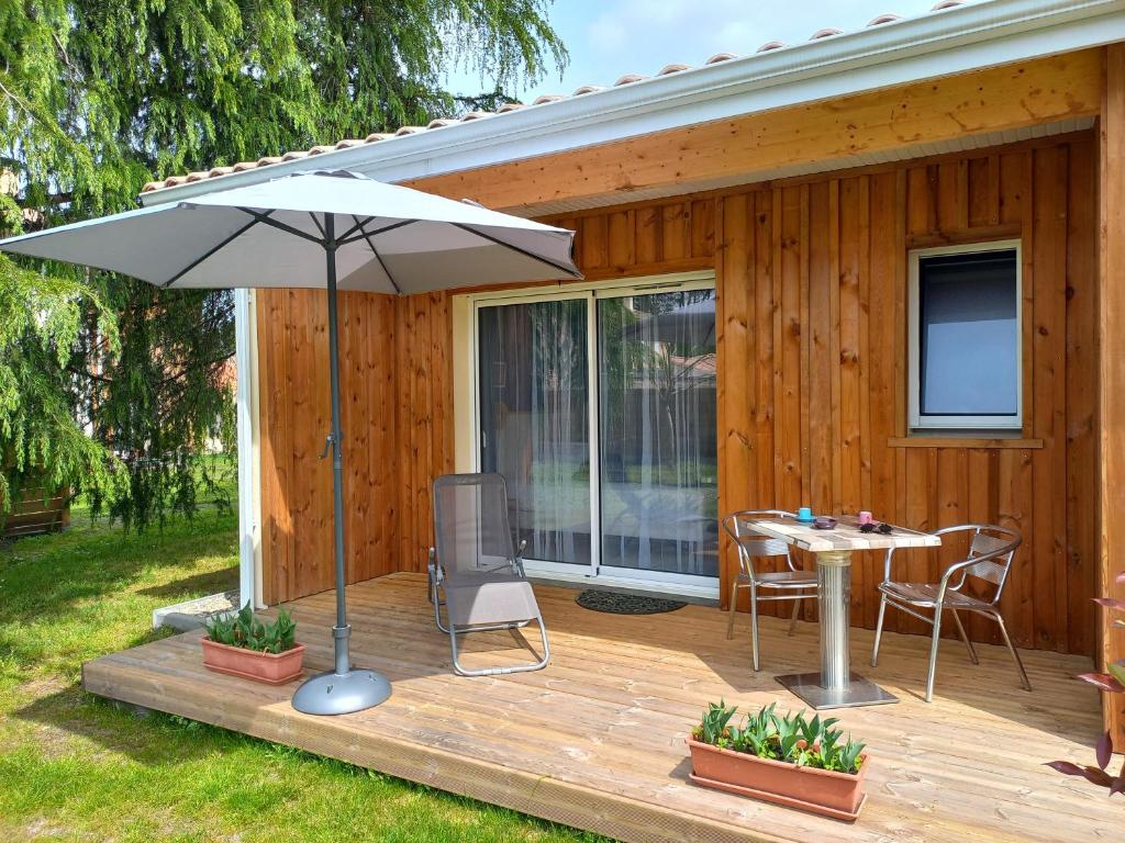 a wooden deck with a table and an umbrella at C La Belle Vie in Pessac