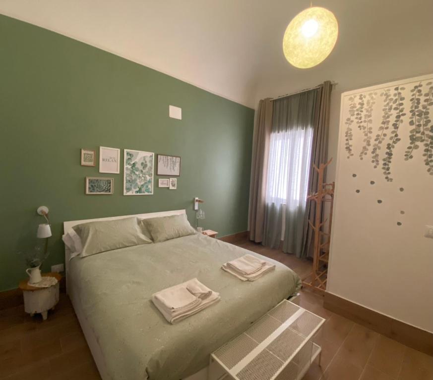 een slaapkamer met een bed met twee handdoeken erop bij La Casa di LiLù in Taranto