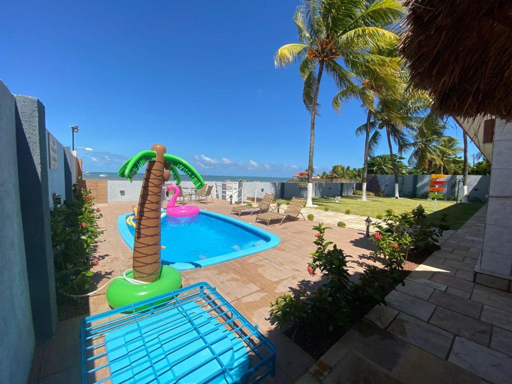 a swimming pool with a water slide in a resort at Casa Pé na Areia in São José da Coroa Grande