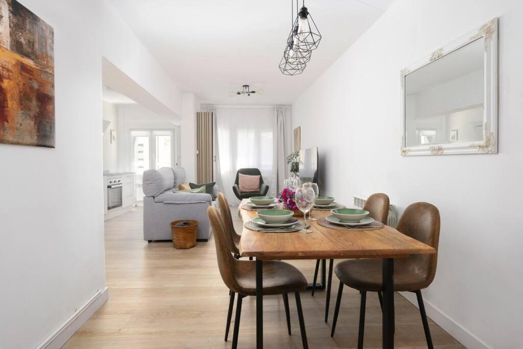 een eetkamer en een woonkamer met een tafel en stoelen bij MyHouseSpain - Acogedor piso nuevo en Gijón in Gijón
