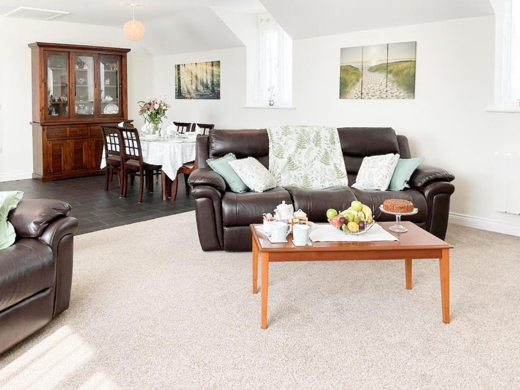 a living room with a couch and a coffee table at Leddon Farm Annexe-uk39616 in Gooseham