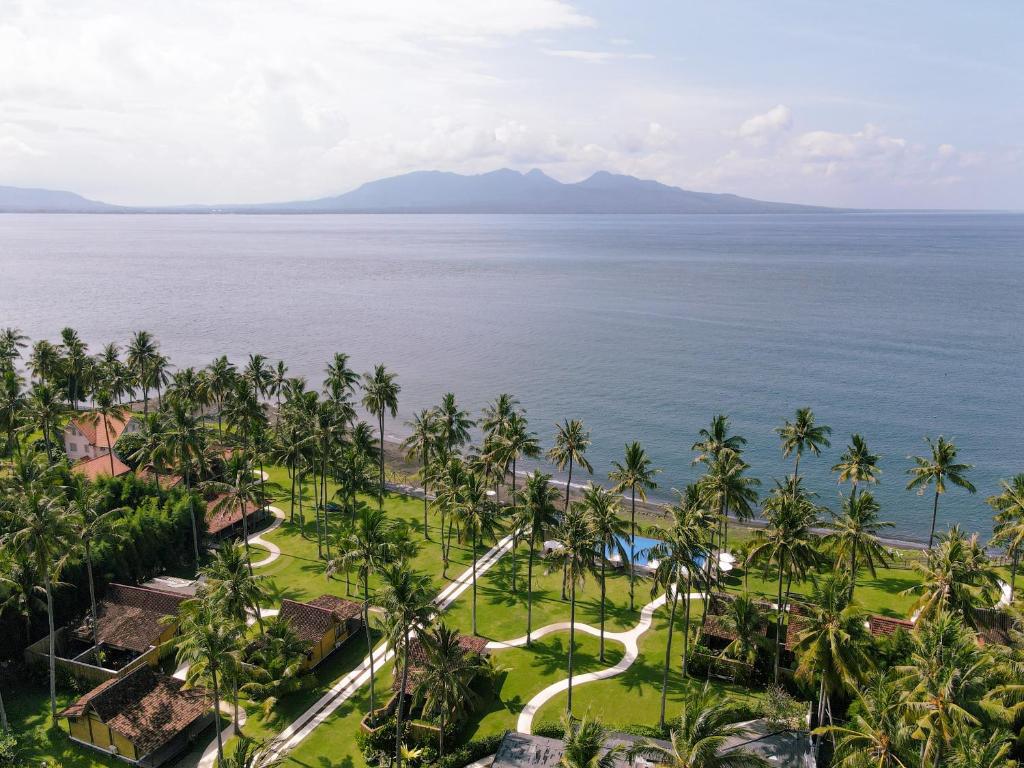 einen Luftblick auf ein Resort mit Palmen und dem Meer in der Unterkunft Villa So Long Banyuwangi - Ijen in Banyuwangi