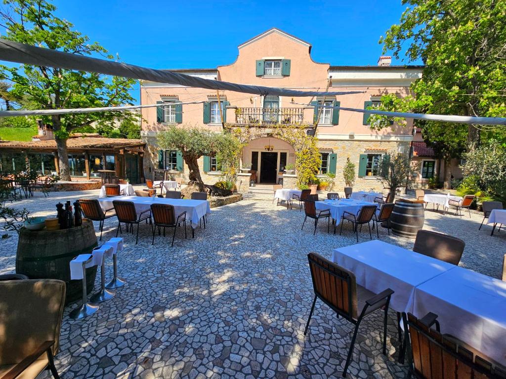 a patio with tables and chairs in front of a building at Villa Andor in Ankaran