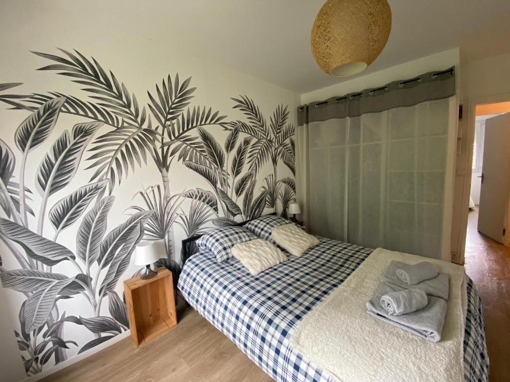1 dormitorio con 1 cama con papel pintado tropical en Superbe appartement au calme avec parking gratuit. en Mérignac