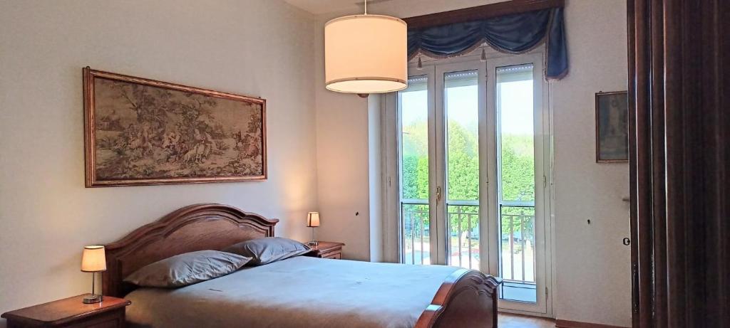 sypialnia z łóżkiem i dużym oknem w obiekcie Casa Caty w mieście Pinerolo
