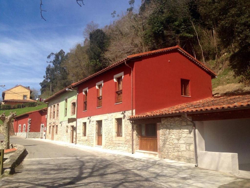 a red building on the side of a street at La Casuca del Esbardu Hotel in Vilde