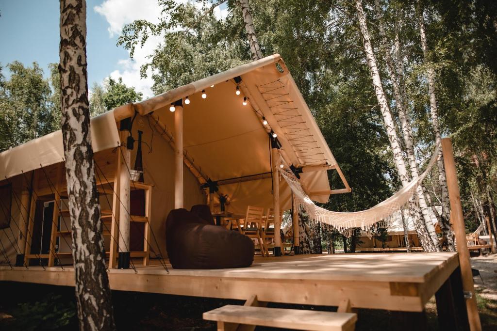 a tent with a hammock on a wooden deck at Glamping Mandra Kanev in Leplyavo