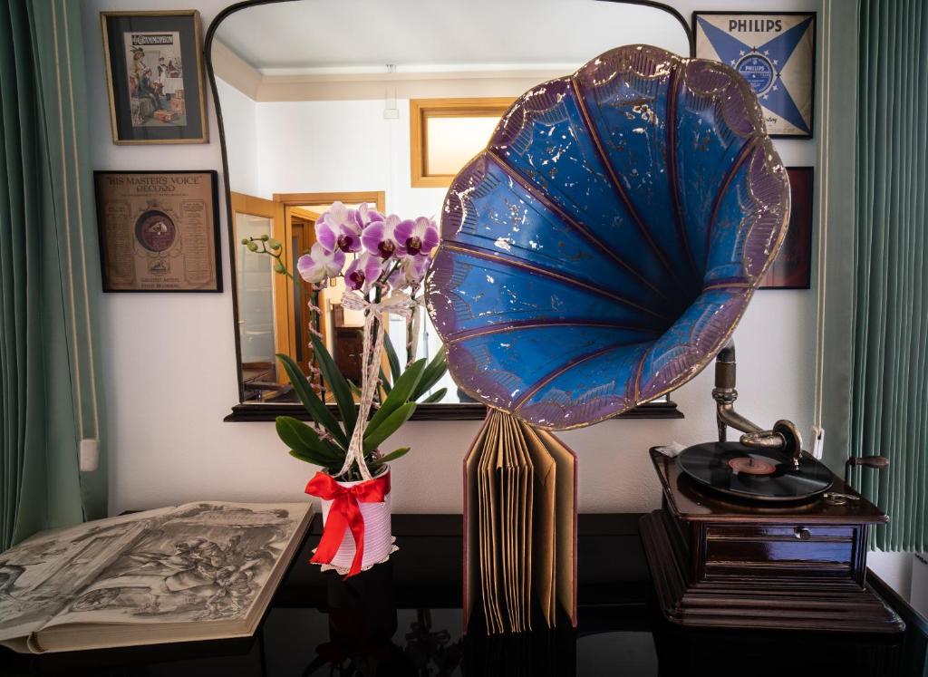 una mesa con un jarrón de flores y un ventilador en Casa dell'Architetto, en Chioggia
