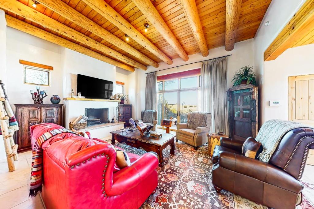 una sala de estar con muebles de color rojo y techo de madera. en Casa de Gran Vista, en Santa Fe