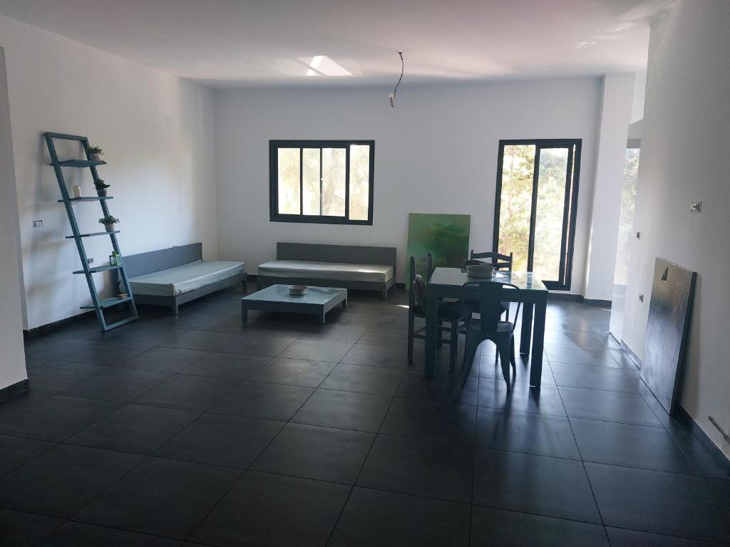uma sala de estar com uma mesa e um sofá em The Green Blue House em Dar el Koudia