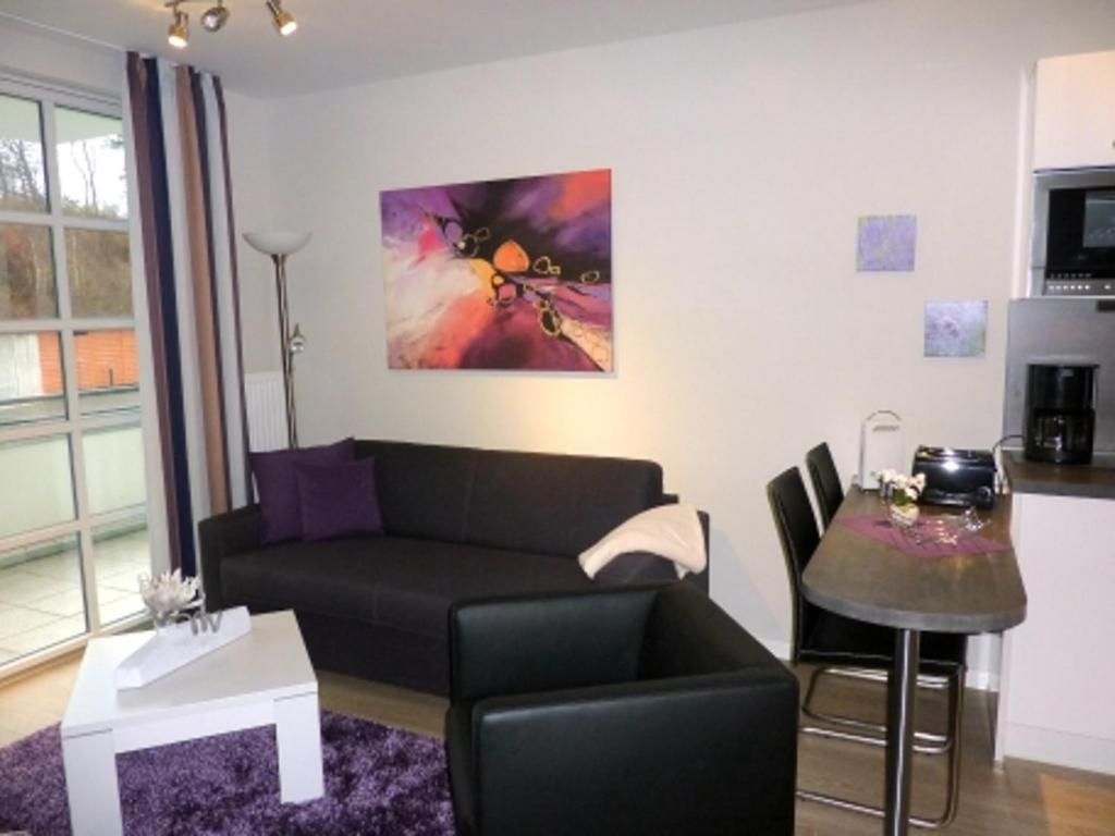 ein Wohnzimmer mit einem Sofa und einem Tisch in der Unterkunft Residenz am Balmer See - BS 07 mit Wellnessbereich in Balm