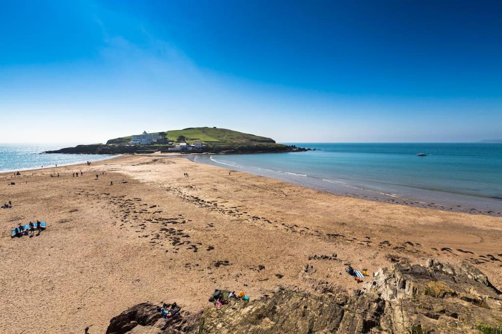 a beach with a group of people on the sand at Fairwinds,Bigbury on sea ,Three-bed Beach House in Bigbury on Sea