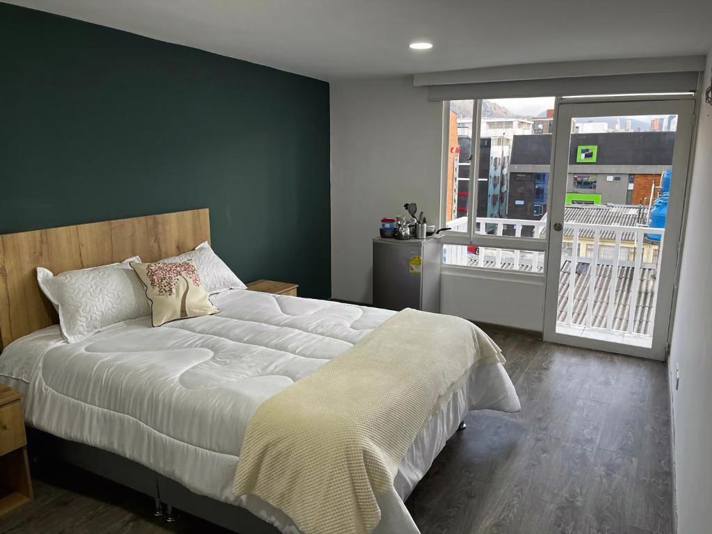 een slaapkamer met een groot bed en een groot raam bij Apartamentos céntricos y cómodos en Chapinero in Bogota