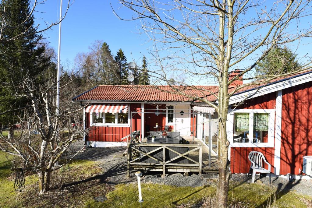 uma casa vermelha e branca com um alpendre em Cozy cottage with 10 beds near Landvetter em Landvetter