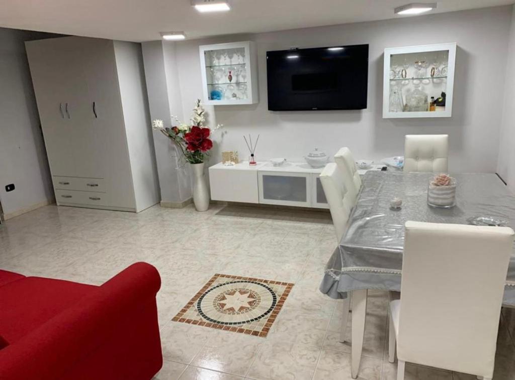 a living room with a dining table and a tv at Casa Antonella in Naples