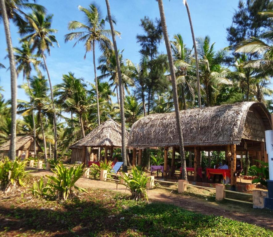 un resort sulla spiaggia con palme di Sukriti beach Resort a Varkala
