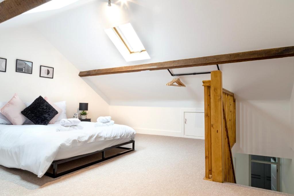 a bedroom with a bed with white sheets and wooden beams at BIG Monthly DIS, Central, Modern, 2bed APT, Sleeps up to 5 in Swindon