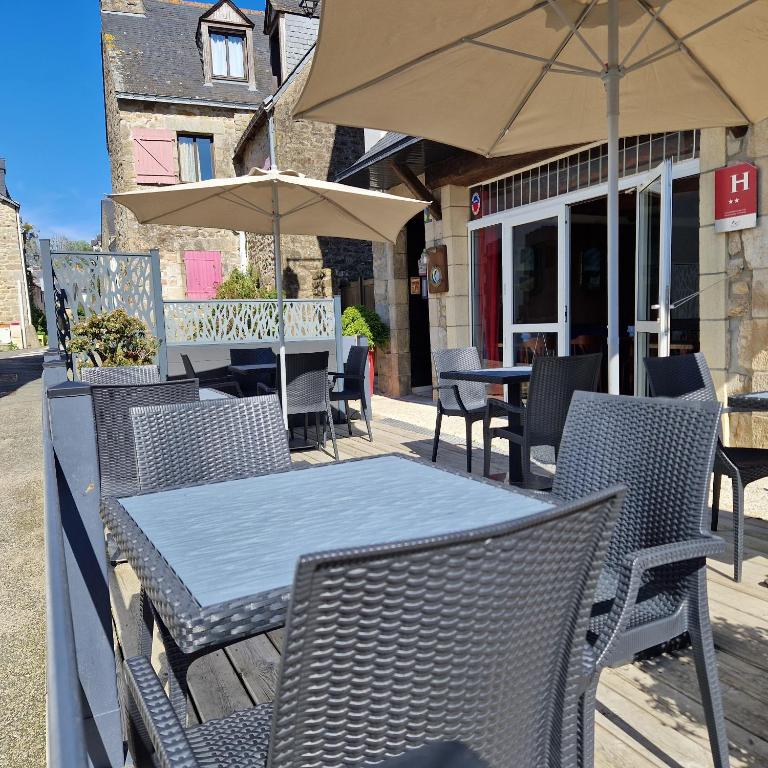 a table and chairs with an umbrella on a patio at Hotel Le Marin in Auray