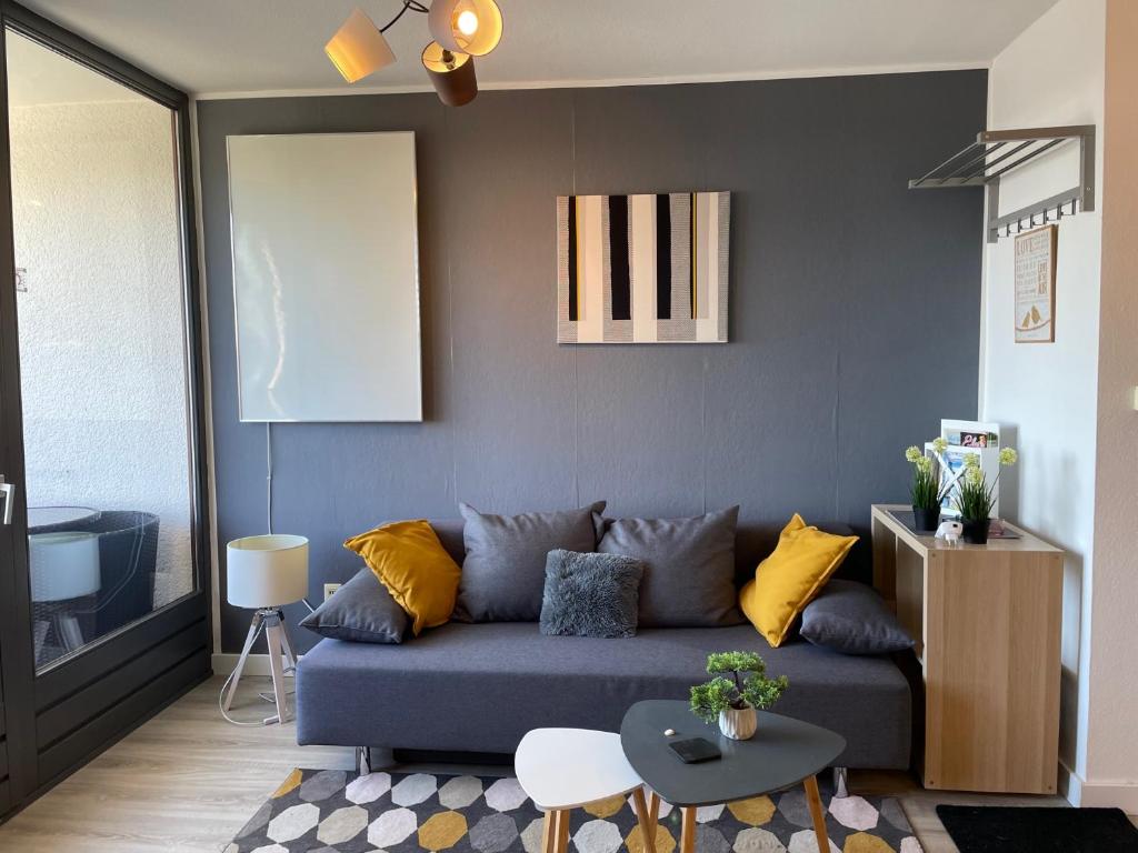 ein Wohnzimmer mit einem blauen Sofa und gelben Kissen in der Unterkunft Apartment Pistenräuber in Winterberg