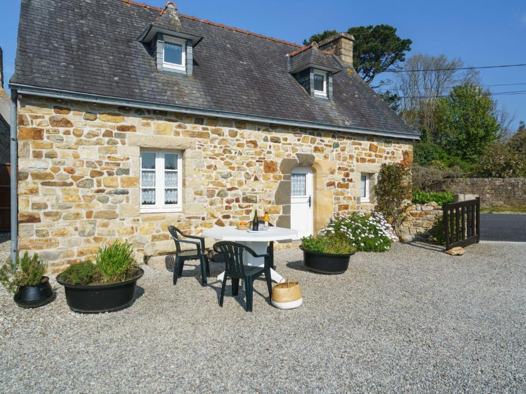 une maison en pierre avec une table et des chaises devant elle dans l'établissement Holiday Home Chez Jeanne by Interhome, à Crozon