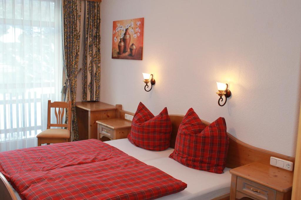 a bedroom with a red bed with red pillows at Appartement Hohe Mut in Obergurgl