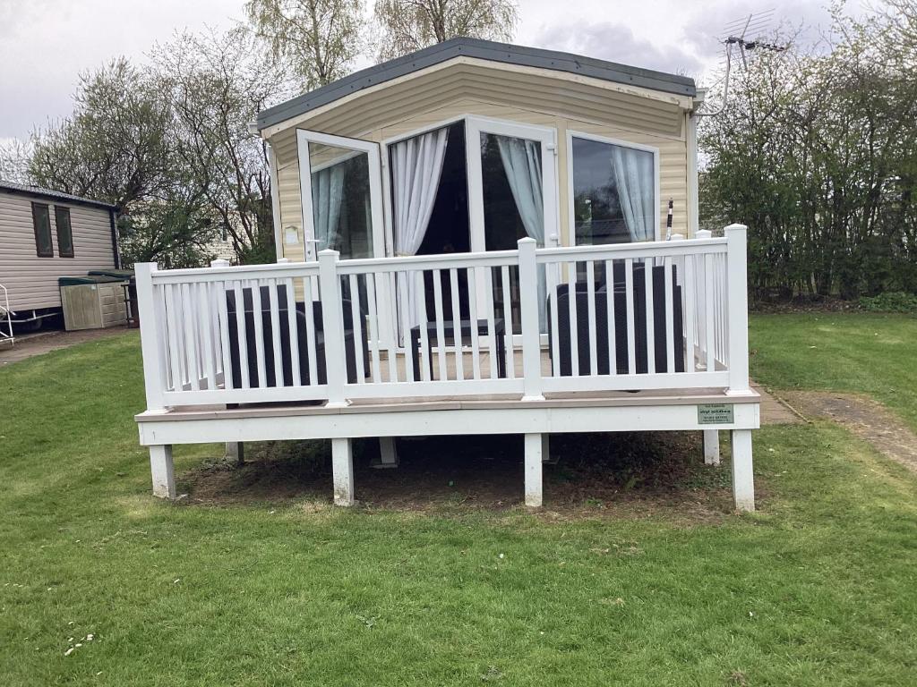 a large white bench in the grass in a yard at Luxury caravan at Seton Sands in Port Seton