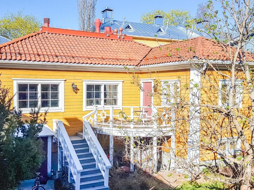 een geel huis met een trap ervoor bij Holiday Home Pispalan elokuvaranta by Interhome in Tampere