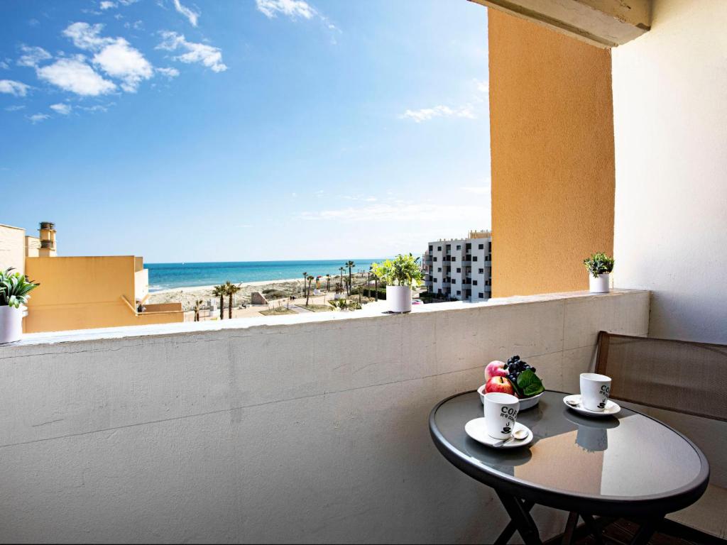 une table sur un balcon avec vue sur la plage dans l'établissement Studio Vistaéro-6 by Interhome, au Barcarès
