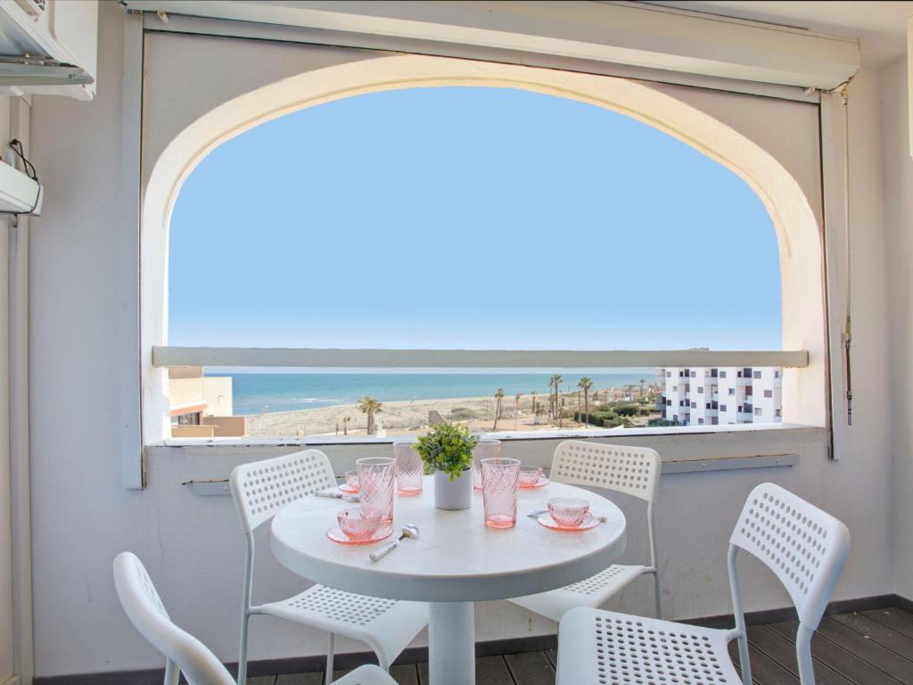 - une table et des chaises blanches avec vue sur la plage dans l'établissement Studio Vistaéro-7 by Interhome, au Barcarès