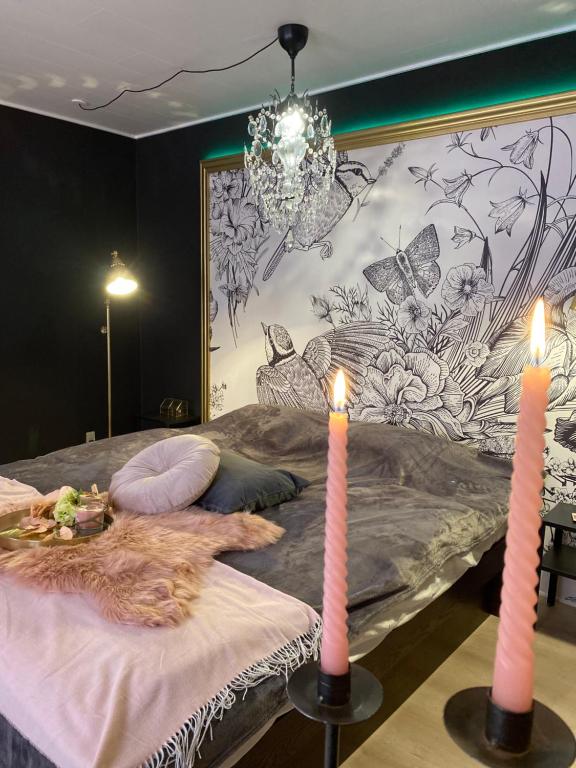 a bedroom with a bed with two candles on it at Slava Kongenstofte house in Nakskov