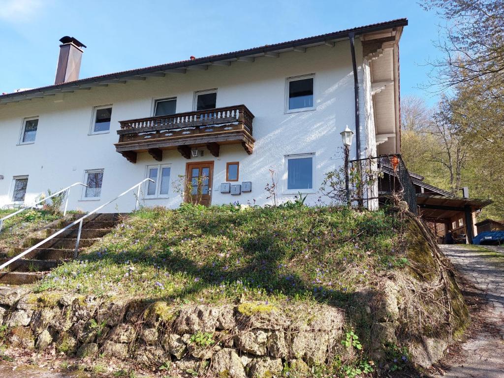 a large white house with a balcony on a hill at Ferienwohnung Grabner in Waging am See