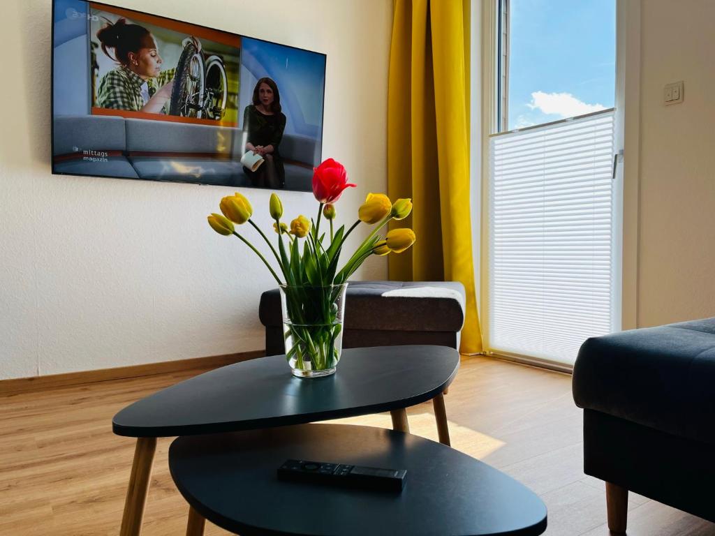 ein Wohnzimmer mit einer Blumenvase auf dem Tisch in der Unterkunft Ferienwohnung am Eberbach in Stadtoldendorf
