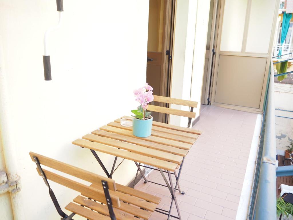 a wooden table with two chairs and a flowerpot on a balcony at Palazzina al Lingotto in Turin