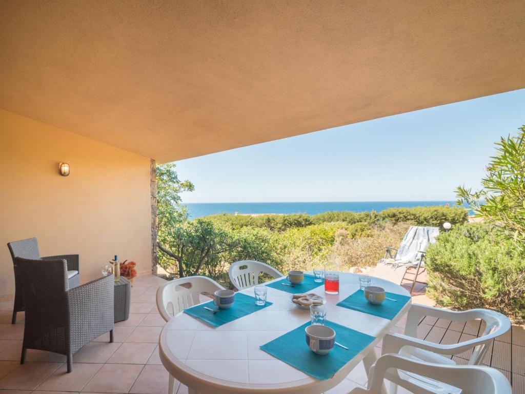 eine Terrasse mit Tisch und Stühlen und dem Meer in der Unterkunft Holiday Home Corbezzolo by Interhome in Costa Paradiso