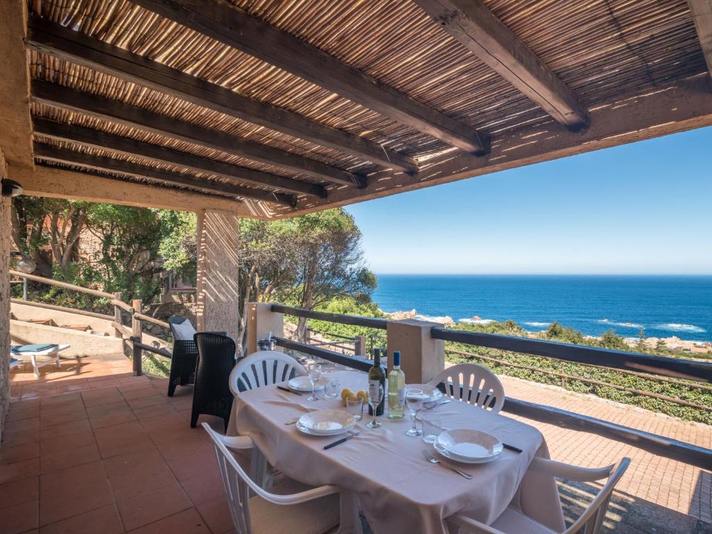a dining table on a patio with a view of the ocean at Holiday Home Li Cossi by Interhome in Costa Paradiso