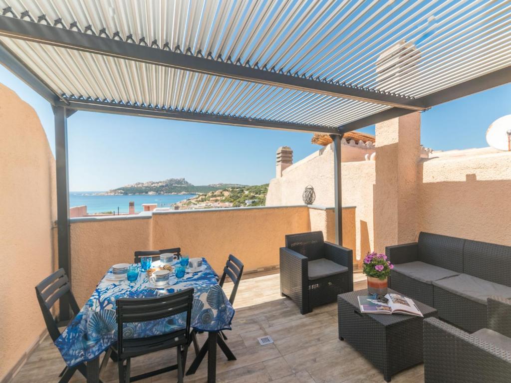 um pátio com uma mesa e vista para o oceano em Apartment Baia blu by Interhome em Santa Teresa Gallura