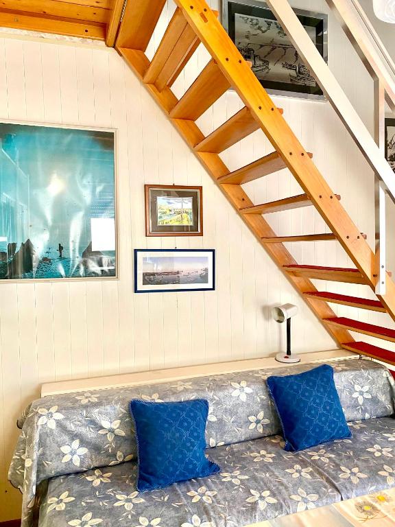 a couch with blue pillows sitting in a room at LA casa nell'angolo in Marettimo