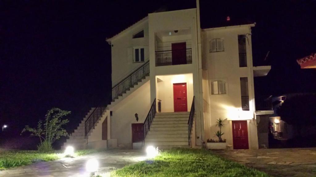a white building with stairs in the night at Eva Apartments in Svoronata