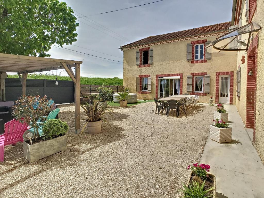 a patio with a table and chairs and a house at Ferme Gascone proche Marciac in Bars