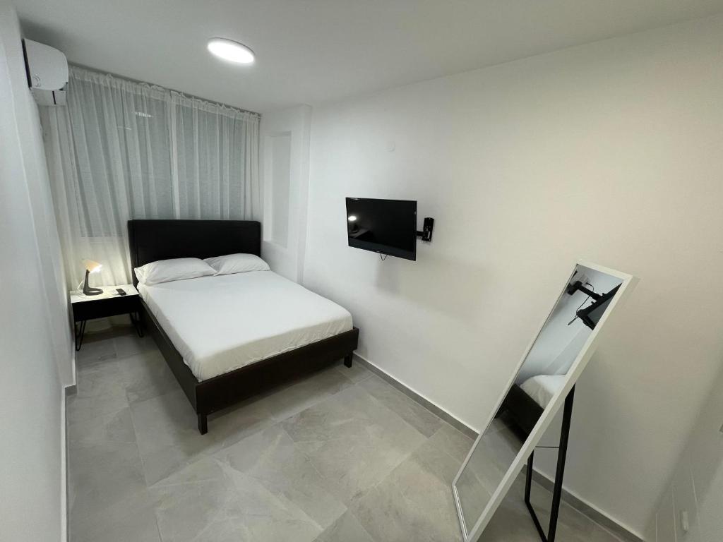 バト・ヤムにあるApartment Modernのベッドとテレビのある小さな寝室