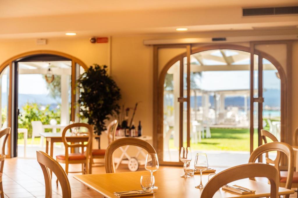 a dining room with a table and chairs and windows at Hotel dP Olbia - Sardinia in Olbia