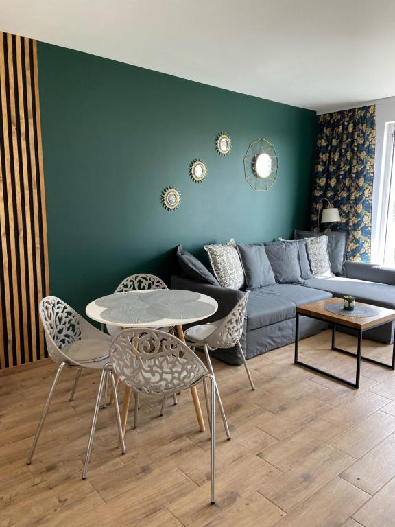 sala de estar con sofá, mesa y sillas en Apartament Nina, en Gdansk