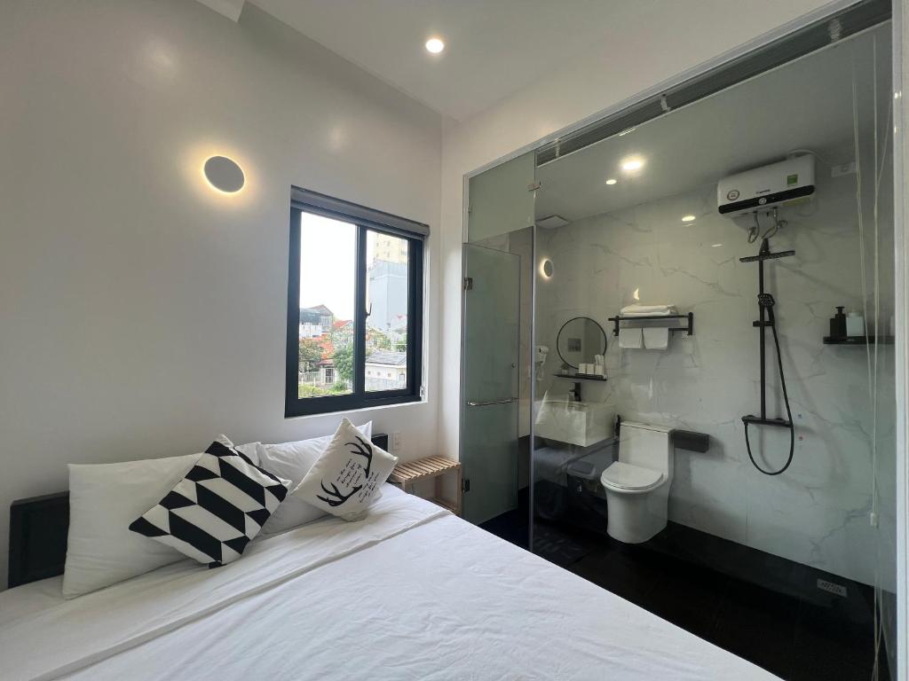 - une chambre avec un grand lit blanc et une fenêtre dans l'établissement ANH’s HOUSE, à Hue