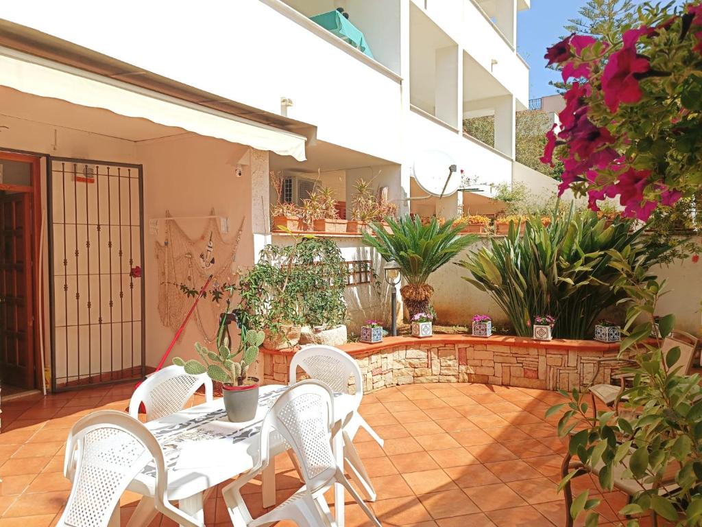 a patio with a table and chairs and potted plants at Princess House Palermo - Intero Appartamento - Mondello in Mondello