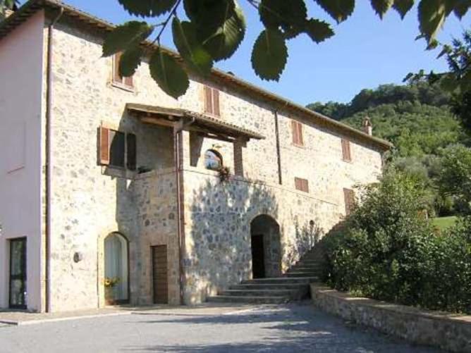 un gran edificio de piedra con escaleras que conducen a una puerta en Villa Acquafredda en Orvieto