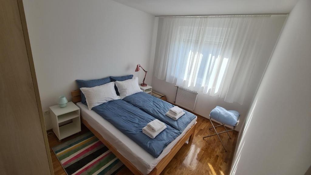 een kleine slaapkamer met een bed en een raam bij Apartman Centar Bečej in Bečej