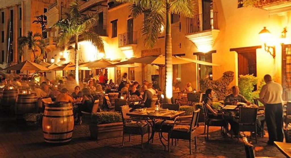 un gruppo di persone sedute al ristorante di notte di Suites By SalcedO a Santo Domingo